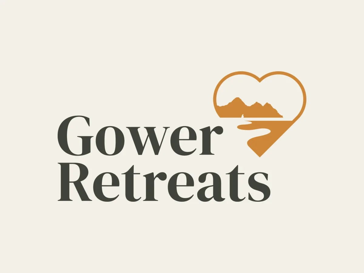 The Gower Retreats logo: a heart framing Three Cliffs and a river winding out to sea