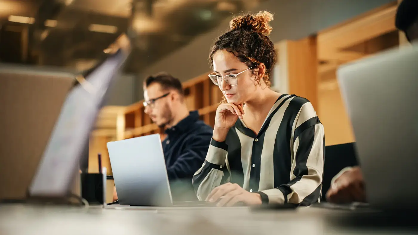 People working on laptops in a bright office